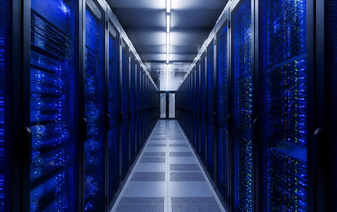 Data centre aisle with rows of servers lit in blue